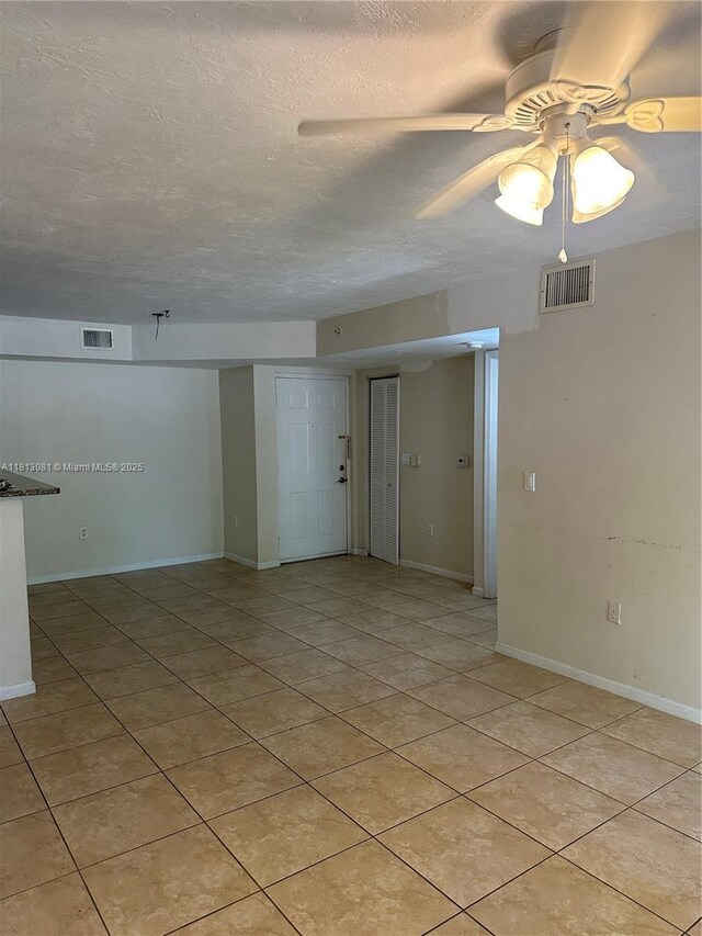 4828 N State Road 7 Unit 8107, Coconut Creek, FL 33073 - spare room featuring ceiling fan, light tile patterned flooring, a textured ceiling, and baseboards