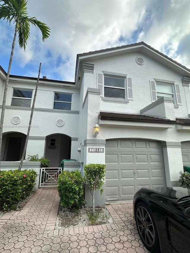 11281 NW 42nd Ter Unit 0, Doral, FL 33178 - view of property with stucco siding, an attached garage, and a gate