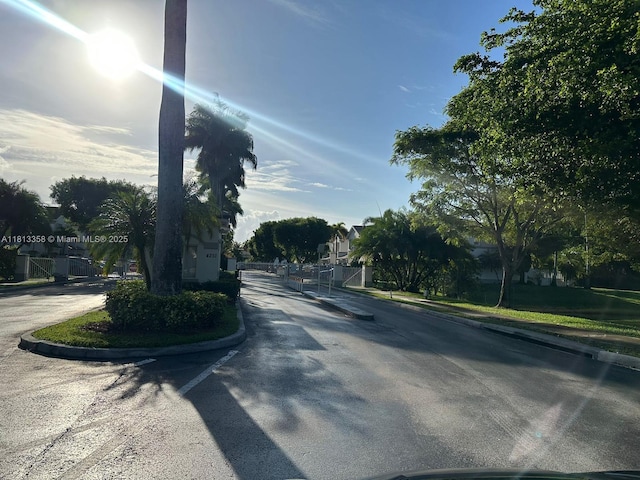 11281 NW 42nd Ter Unit 0, Doral, FL 33178 - view of asphalt road with curbs, a gated entry, a gate, and sidewalks