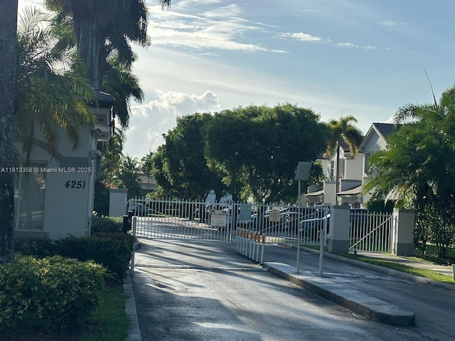 11281 NW 42nd Ter Unit 0, Doral, FL 33178 - view of asphalt street with a gate, curbs, sidewalks, and a residential view
