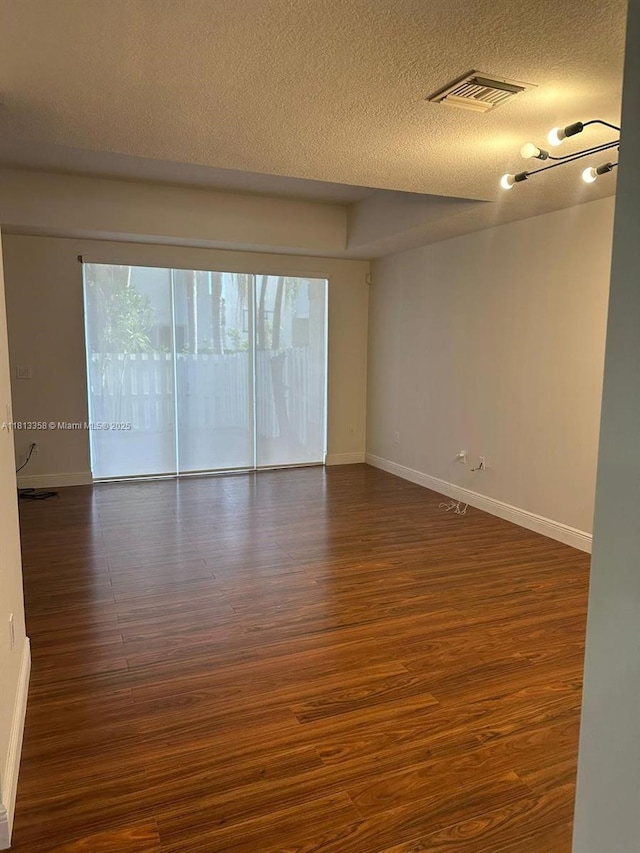 11281 NW 42nd Ter Unit 0, Doral, FL 33178 - empty room featuring dark wood-type flooring, baseboards, and a textured ceiling