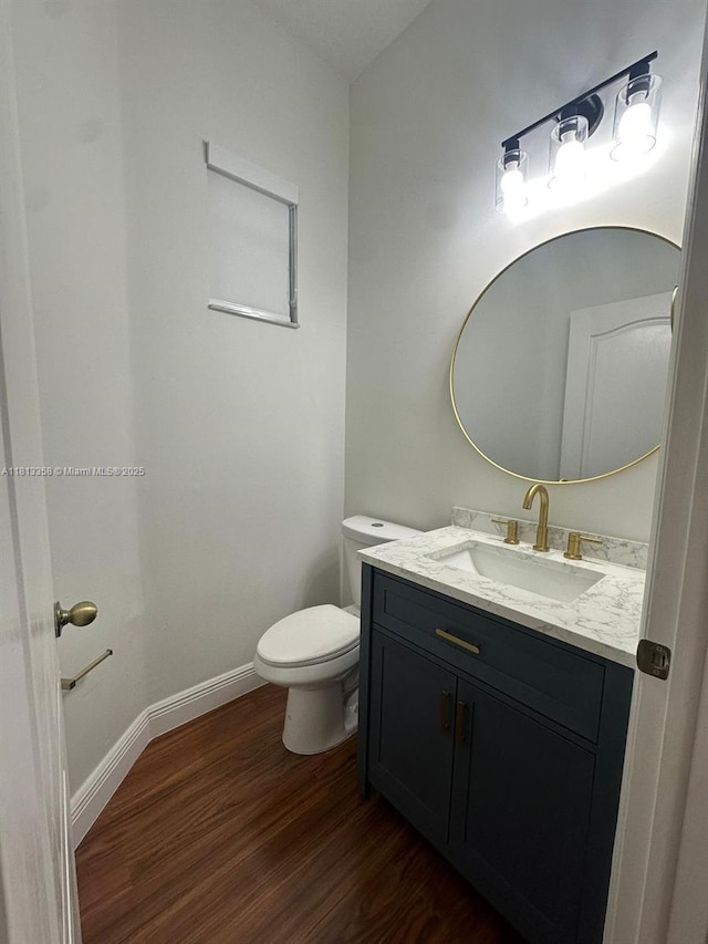 11281 NW 42nd Ter Unit 0, Doral, FL 33178 - half bathroom featuring wood finished floors, vanity, toilet, and baseboards