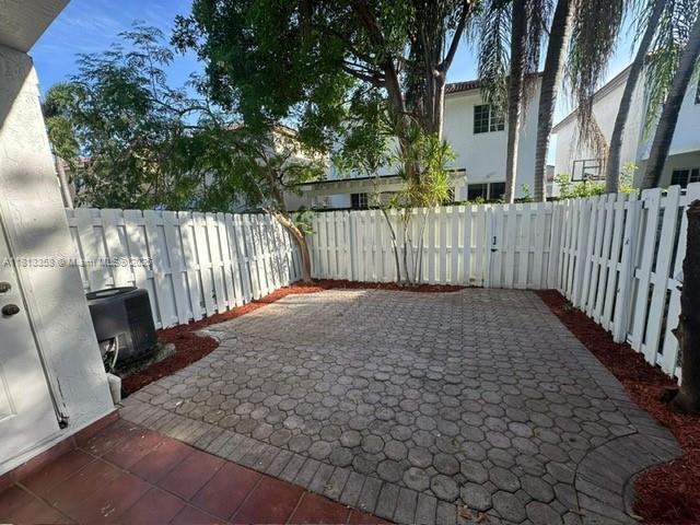 11281 NW 42nd Ter Unit 0, Doral, FL 33178 - fenced backyard featuring a patio and cooling unit