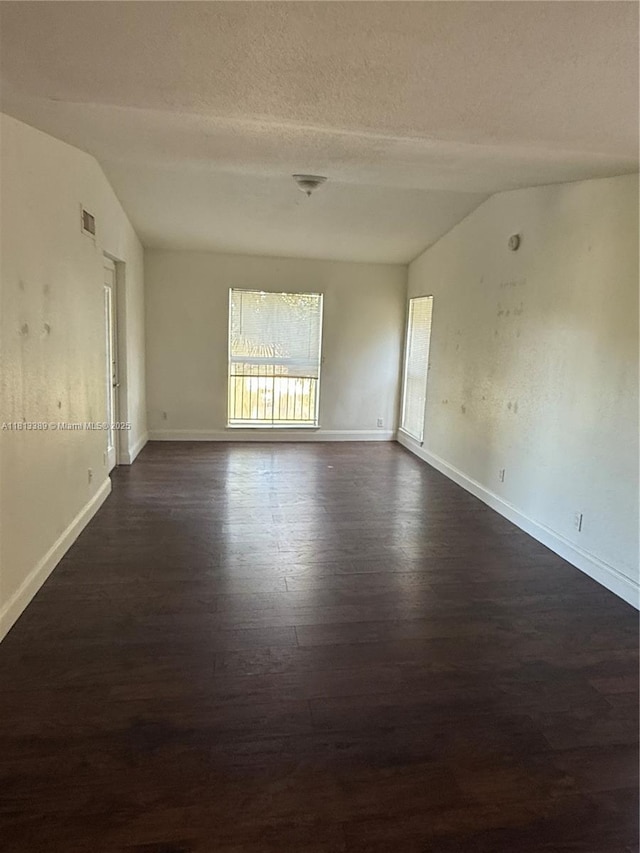 833 Riverside Dr Unit 834, Coral Springs, FL 33071 - spare room with lofted ceiling, dark wood-style floors, baseboards, and a textured ceiling