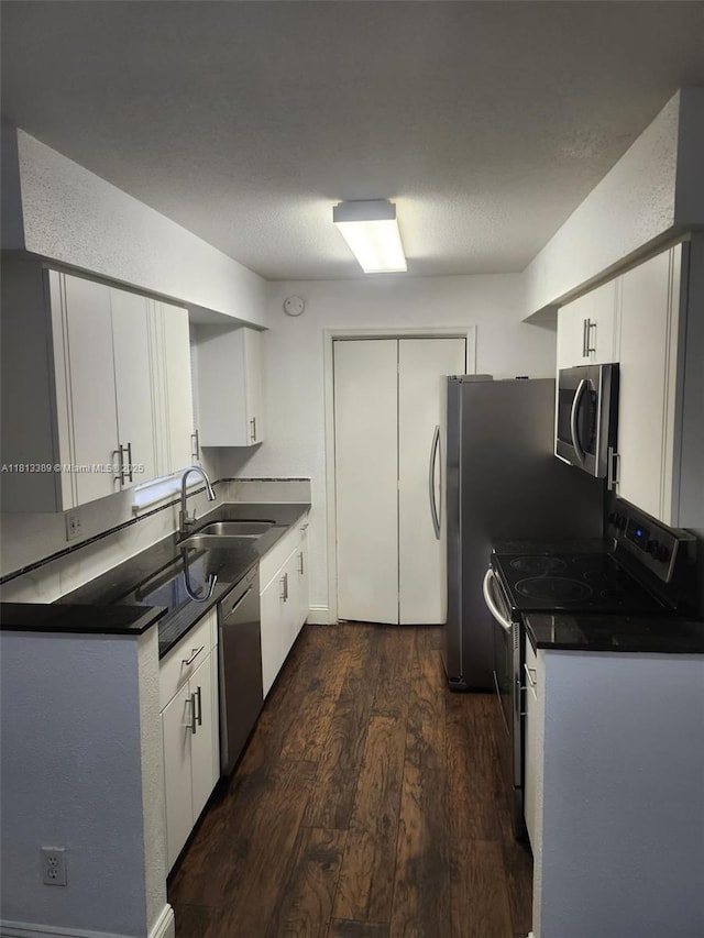 833 Riverside Dr Unit 834, Coral Springs, FL 33071 - kitchen with appliances with stainless steel finishes, dark wood-type flooring, dark countertops, a sink, and white cabinetry