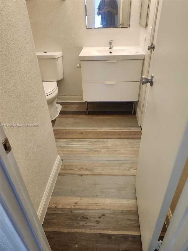 833 Riverside Dr Unit 834, Coral Springs, FL 33071 - half bath featuring vanity, toilet, wood finished floors, baseboards, and a textured wall