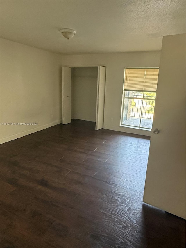 833 Riverside Dr Unit 834, Coral Springs, FL 33071 - spare room featuring dark wood-style floors, baseboards, and a textured ceiling