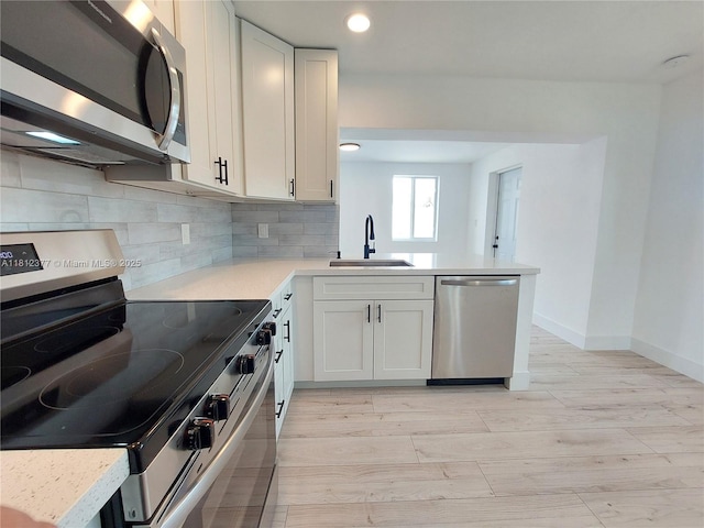 4579 NW 16th Way, Tamarac, FL 33309 - kitchen featuring stainless steel appliances, a sink, light wood finished floors, light countertops, and backsplash