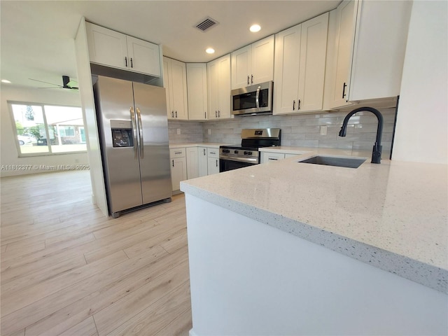 4579 NW 16th Way, Tamarac, FL 33309 - kitchen with stainless steel appliances, a sink, light stone countertops, decorative backsplash, and a ceiling fan