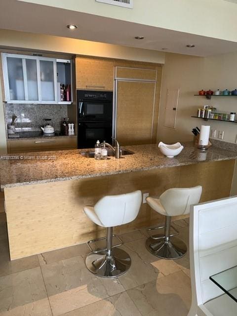1830 S Ocean Dr Unit 2103, Hallandale Beach, FL 33009 - kitchen with a sink, stone countertops, a breakfast bar area, paneled fridge, and tasteful backsplash