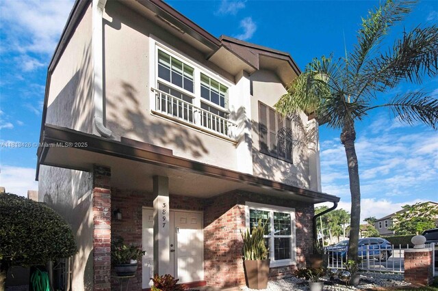 3897 NW 122nd Ter, Sunrise, FL 33323 - view of property exterior with stucco siding, a balcony, and brick siding