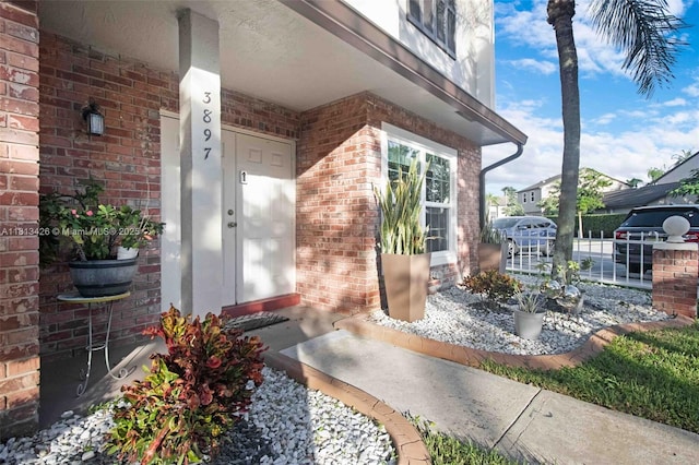 3897 NW 122nd Ter, Sunrise, FL 33323 - view of exterior entry featuring brick siding and a porch