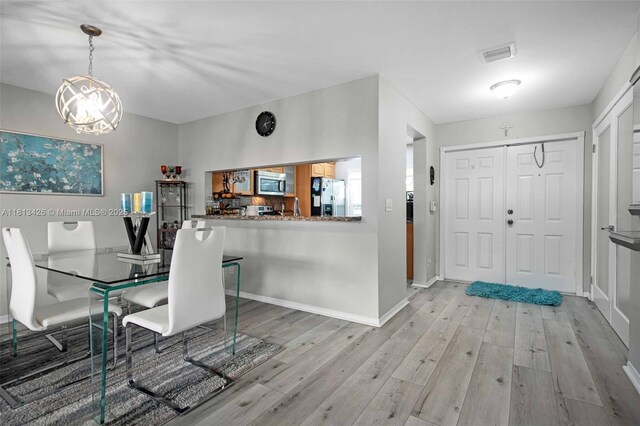 3897 NW 122nd Ter, Sunrise, FL 33323 - dining area featuring light wood finished floors, a chandelier, and baseboards