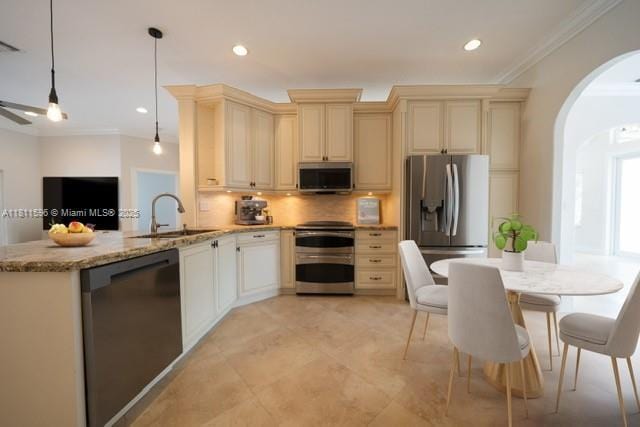 16404 Diamond Pl, Weston, FL 33331 - kitchen featuring appliances with stainless steel finishes, cream cabinetry, a sink, arched walkways, and a peninsula