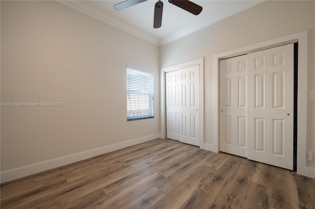 16404 Diamond Pl, Weston, FL 33331 - unfurnished bedroom with multiple closets, crown molding, wood finished floors, baseboards, and a ceiling fan