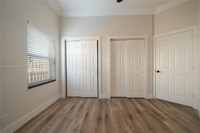 16404 Diamond Pl, Weston, FL 33331 - unfurnished bedroom featuring multiple closets, crown molding, baseboards, and wood finished floors