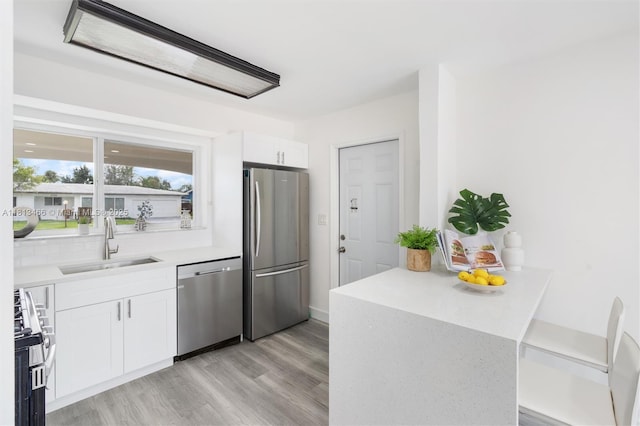 4331 NW 9th Ct, Coconut Creek, FL 33066 - kitchen featuring stainless steel appliances, a sink, white cabinets, light countertops, and light wood-style floors