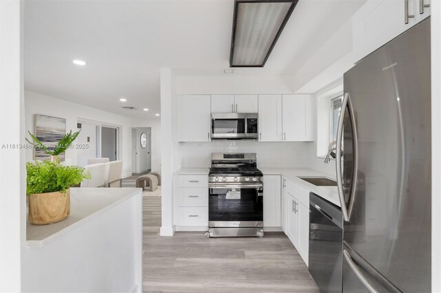 4331 NW 9th Ct, Coconut Creek, FL 33066 - kitchen featuring appliances with stainless steel finishes, a sink, light countertops, light wood-style flooring, and recessed lighting