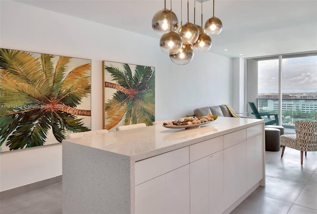 4001 S Ocean Dr Unit 14H, Hollywood, FL 33019 - kitchen featuring modern cabinets, floor to ceiling windows, decorative light fixtures, white cabinetry, and light stone countertops