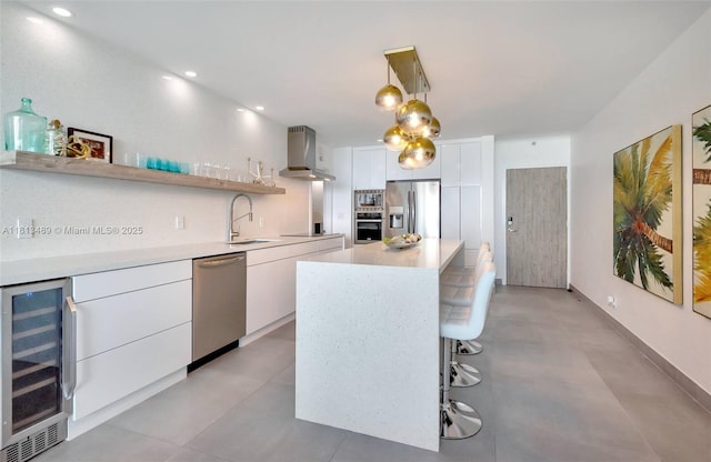 4001 S Ocean Dr Unit 14H, Hollywood, FL 33019 - kitchen with island exhaust hood, appliances with stainless steel finishes, wine cooler, light countertops, and white cabinets