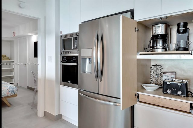 4001 S Ocean Dr Unit 14H, Hollywood, FL 33019 - kitchen with stainless steel appliances, white cabinets, baseboards, light countertops, and light tile patterned floors