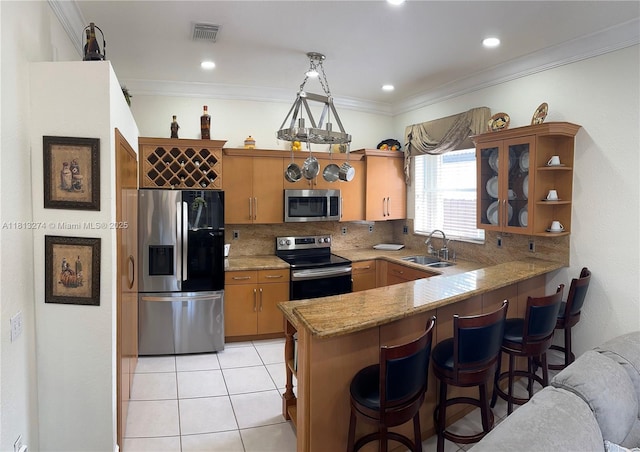 8792 NW 167th St, Miami Lakes, FL 33018 - kitchen with stainless steel appliances, a sink, decorative backsplash, a peninsula, and a kitchen bar