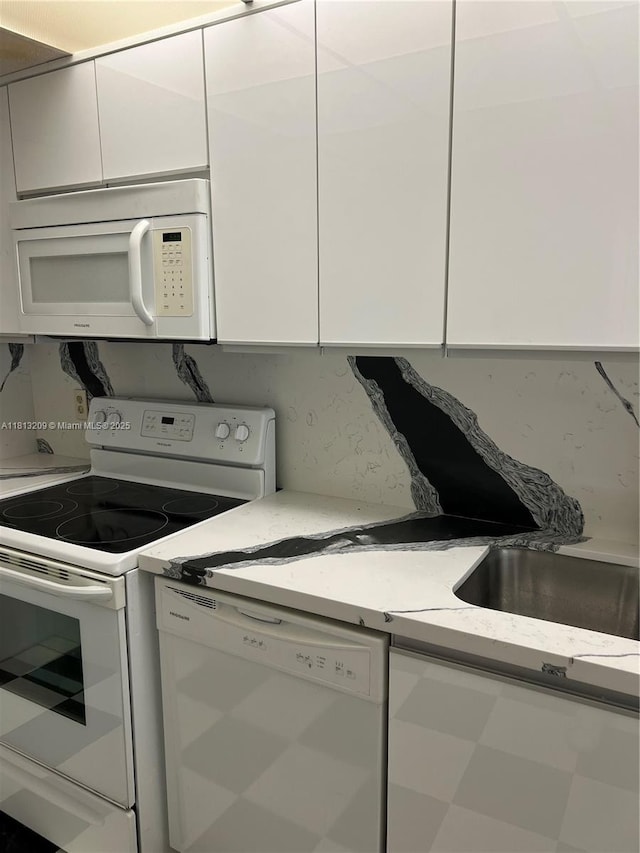 3475 S Ocean Blvd Unit 1130, Palm Beach, FL 33480 - kitchen featuring white appliances, white cabinetry, and light stone countertops