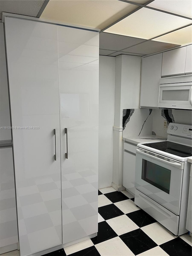 3475 S Ocean Blvd Unit 1130, Palm Beach, FL 33480 - kitchen with white appliances, light flooring, light countertops, and white cabinets