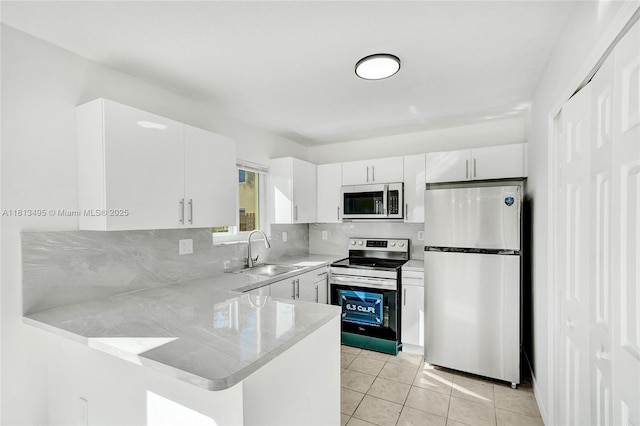 3398 NE 9th Dr Unit 104, Homestead, FL 33033 - kitchen with stainless steel appliances, a sink, light countertops, a peninsula, and white cabinets