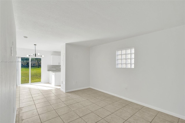 3398 NE 9th Dr Unit 104, Homestead, FL 33033 - unfurnished room featuring light tile patterned floors, a chandelier, baseboards, and a textured ceiling