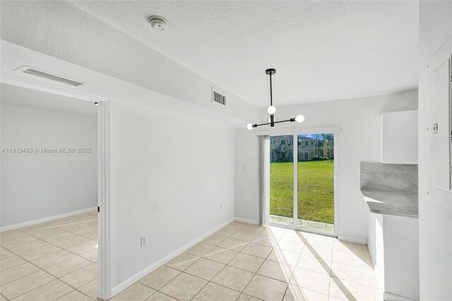 3398 NE 9th Dr Unit 104, Homestead, FL 33033 - unfurnished dining area featuring light tile patterned floors, a chandelier, baseboards, and a textured ceiling
