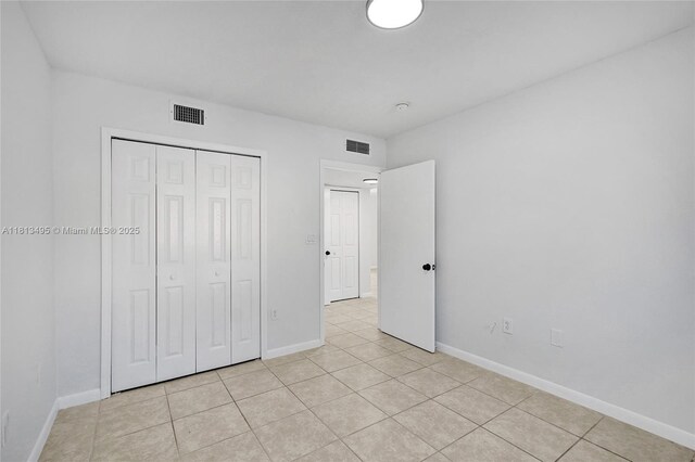 3398 NE 9th Dr Unit 104, Homestead, FL 33033 - unfurnished bedroom with light tile patterned flooring, baseboards, and a closet