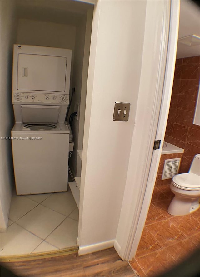 2061 NW 47th Ter Unit 205, Lauderhill, FL 33313 - washroom featuring stacked washer / drying machine, baseboards, and tile patterned flooring
