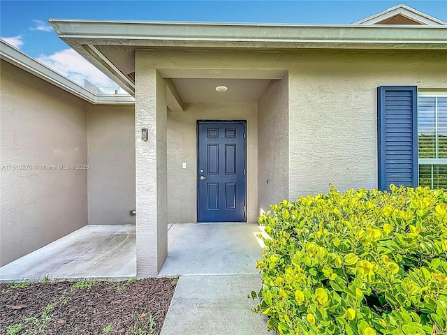 6142 NW Hopkins Ave, Port St Lucie, FL 34986 - view of exterior entry featuring stucco siding
