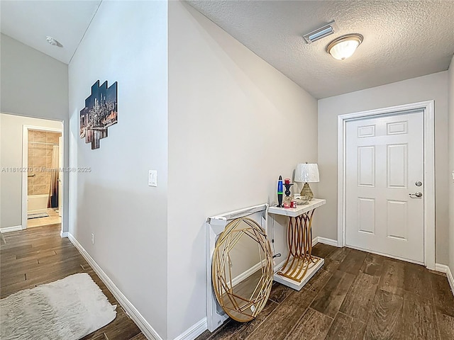 6142 NW Hopkins Ave, Port St Lucie, FL 34986 - hall with wood finished floors, baseboards, a textured ceiling, and lofted ceiling