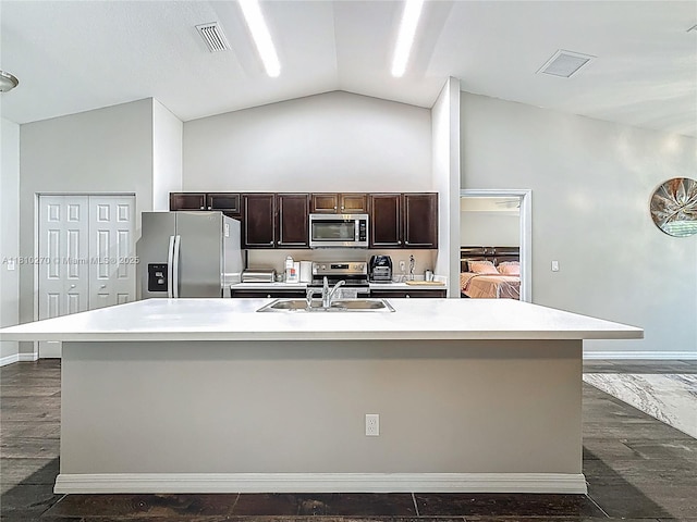 6142 NW Hopkins Ave, Port St Lucie, FL 34986 - kitchen featuring appliances with stainless steel finishes, light countertops, dark brown cabinetry, and lofted ceiling