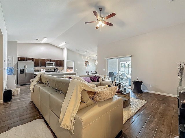 6142 NW Hopkins Ave, Port St Lucie, FL 34986 - living area featuring dark wood-type flooring, vaulted ceiling, a ceiling fan, and baseboards
