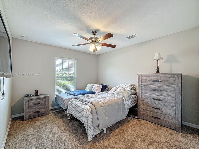 6142 NW Hopkins Ave, Port St Lucie, FL 34986 - bedroom with carpet floors, baseboards, ceiling fan, and a textured ceiling
