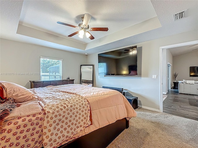6142 NW Hopkins Ave, Port St Lucie, FL 34986 - bedroom with a raised ceiling, baseboards, carpet, a textured ceiling, and ceiling fan