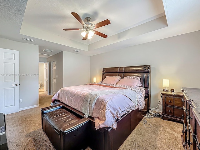 6142 NW Hopkins Ave, Port St Lucie, FL 34986 - carpeted bedroom featuring a raised ceiling, baseboards, and a ceiling fan
