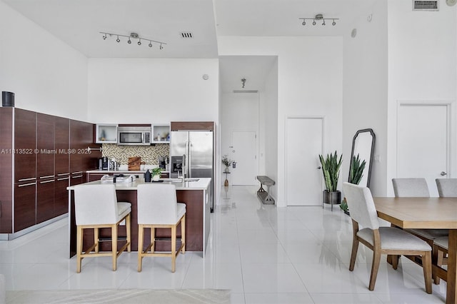1900 N Bayshore Dr Unit 603, Miami, FL 33132 - kitchen with modern cabinets, rail lighting, stainless steel appliances, a high ceiling, and light tile patterned floors