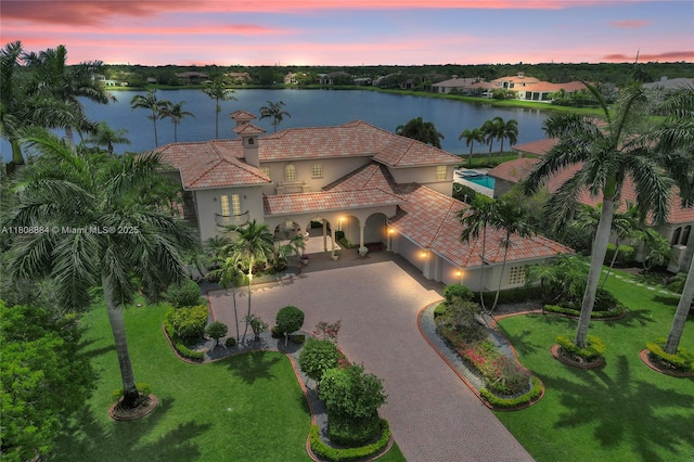 3308 Islewood Ave, Weston, FL 33332 - view of front of house with stucco siding, curved driveway, a water view, and a tile roof