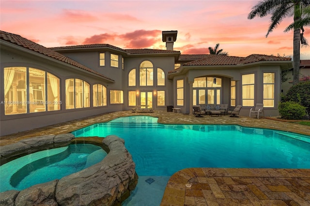 3308 Islewood Ave, Weston, FL 33332 - pool at dusk featuring a patio area, a pool with connected hot tub, and outdoor lounge area
