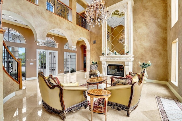 3308 Islewood Ave, Weston, FL 33332 - living area with a chandelier, a high ceiling, baseboards, a glass covered fireplace, and arched walkways