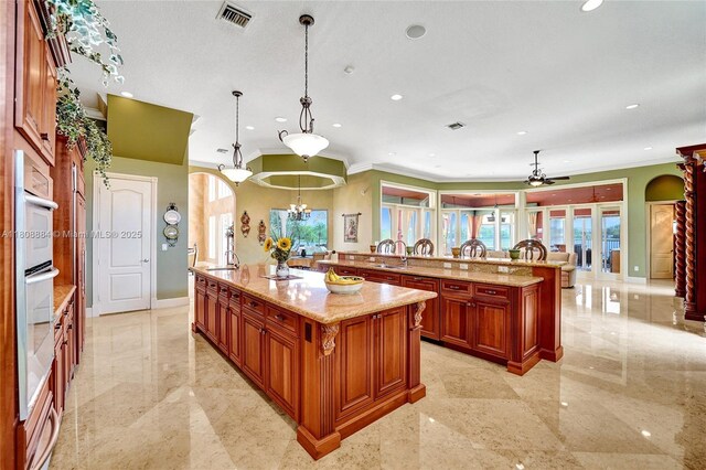3308 Islewood Ave, Weston, FL 33332 - kitchen featuring arched walkways, crown molding, a large island with sink, healthy amount of natural light, and recessed lighting