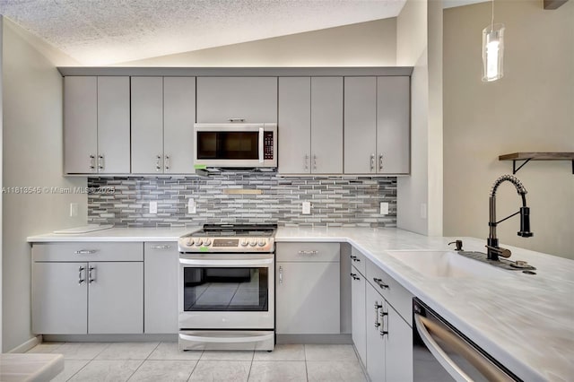 4864 Sable Pine Cir Unit A, West Palm Beach, FL 33417 - kitchen with appliances with stainless steel finishes, gray cabinets, a sink, backsplash, and lofted ceiling