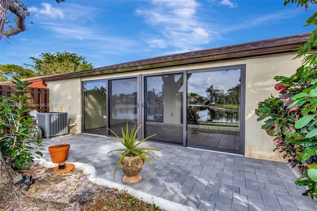 4864 Sable Pine Cir Unit A, West Palm Beach, FL 33417 - back of property featuring a patio area, cooling unit, stucco siding, and a water view