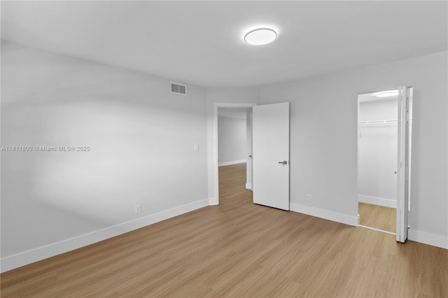 7900 S Colony Cir Unit 206, Tamarac, FL 33321 - unfurnished bedroom with baseboards, light wood-type flooring, a closet, and a walk in closet