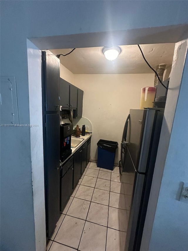 100 NW 204th St Unit 3, Miami Gardens, FL 33169 - kitchen featuring freestanding refrigerator, light tile patterned floors, and dark cabinets