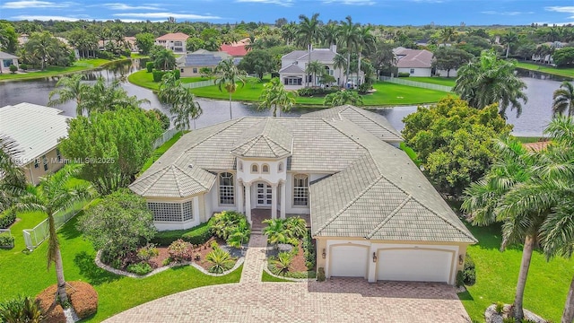 3250 W Stonebrook Cir, Davie, FL 33330 - view of front facade with a tiled roof, decorative driveway, stucco siding, a water view, and a residential view